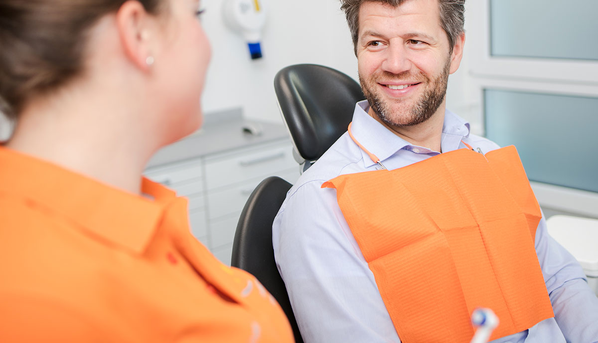 Mann freut sich über gesunde Zähne durch die Professionelle Zahnreinigung in Herzogenrath.